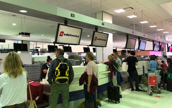 Des passagers se présentent au comptoir d’enregistrement pour s’enregistrer sur le vol Sydney-Zurich. 