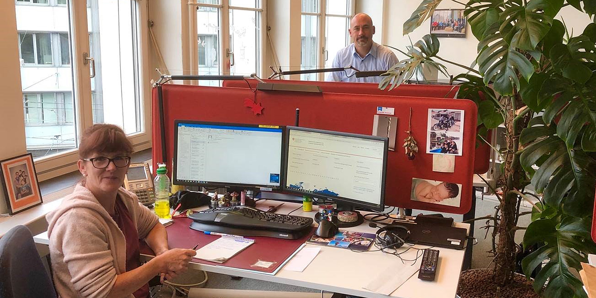 La Helpline du DFAE en action. Deux personnes de l’équipe sont photographiées dans leur bureau à Berne. 