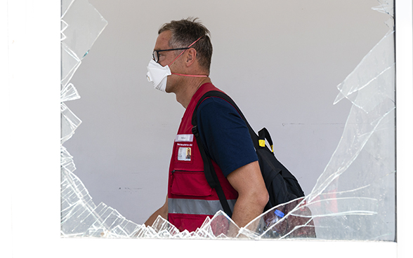 View of an expert from the Swiss Humanitarian Aid Unit through the broken window of a hospital.