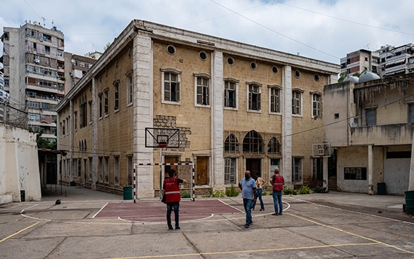 Gli esperti del Corpo svizzero di aiuto umanitario si trovano nel cortile di una scuola.