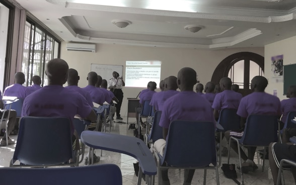 At a seminar, an instructor teaches members of a private security company about adhering to the rules on the use of force