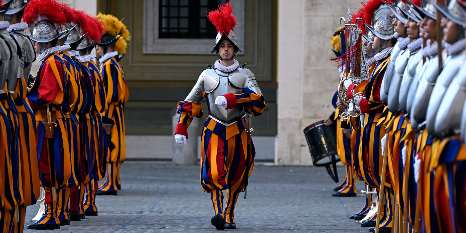 Un garde marche pendant la cérémonie d’assermentation. À sa droite et à sa gauche, ses camarades forment deux files.