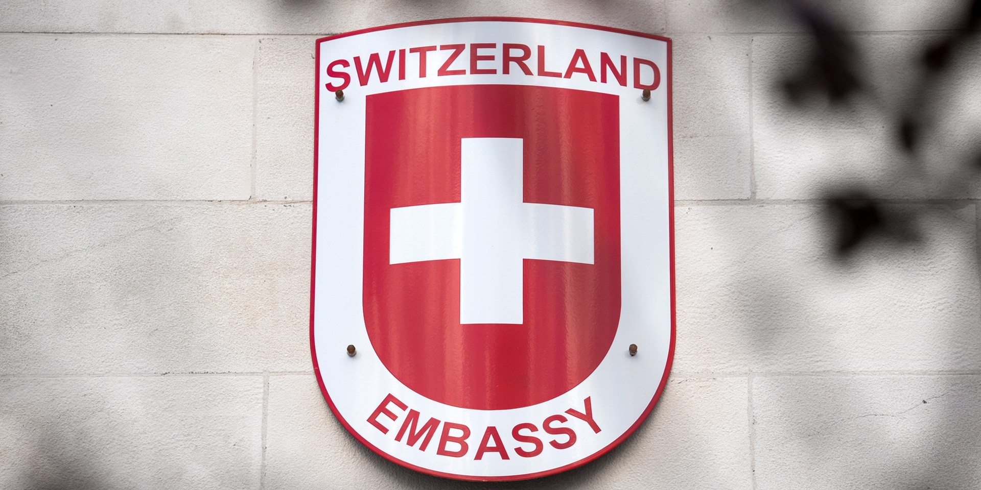 Scudo con la scritta «Switzerland Embassy».