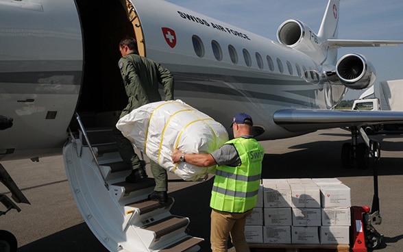Hilfsgüter der Humanitären Hilfe werden auf dem Flughafen Bern-Belp in ein Flugzeug verladen.