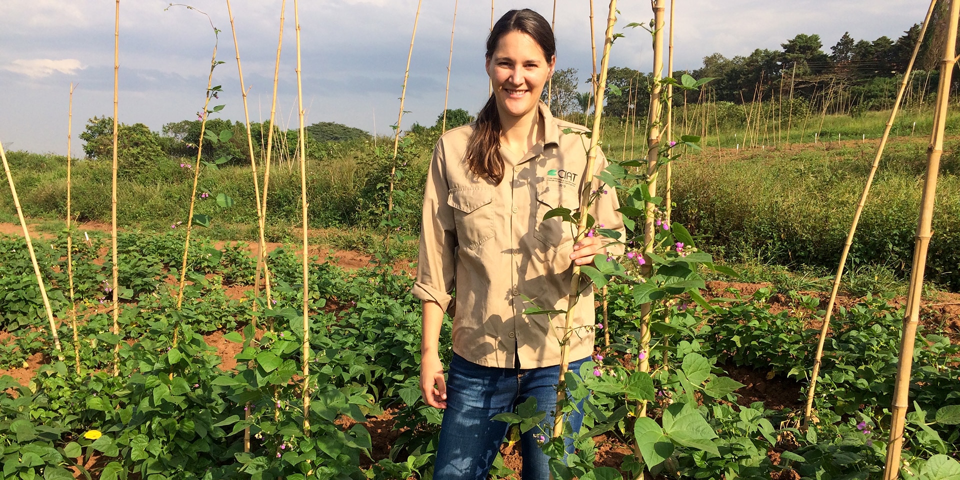 Dr Michelle Nay standing in a bean field in Colombia.