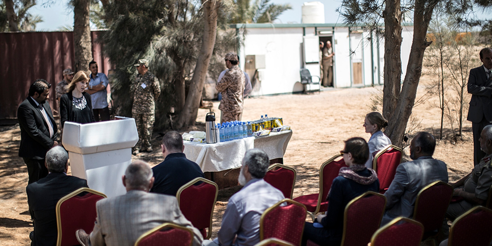 Claudia Marti speaks from a lectern during a conference in Libya.