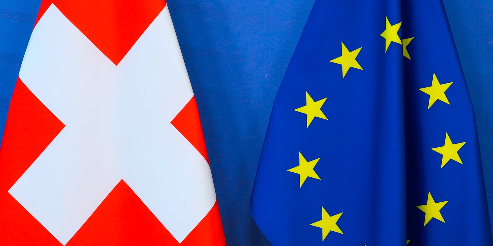 Die Schweizer Fahne und die EU-Flagge wehen nebeneinander.