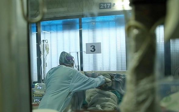 A nurse cares for a patient in a hospital.