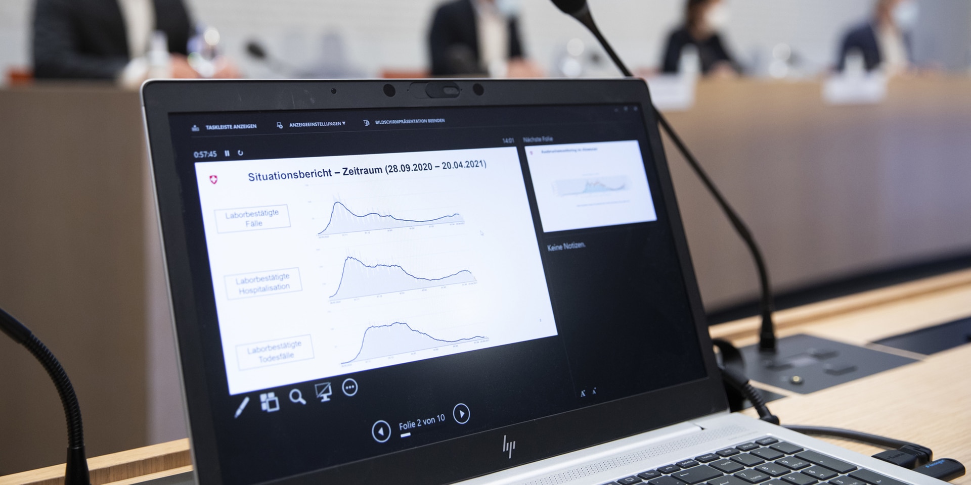 Grafico sullo schermo di un computer con i membri del Consiglio federale sullo sfondo nel centro media di Palazzo federale.