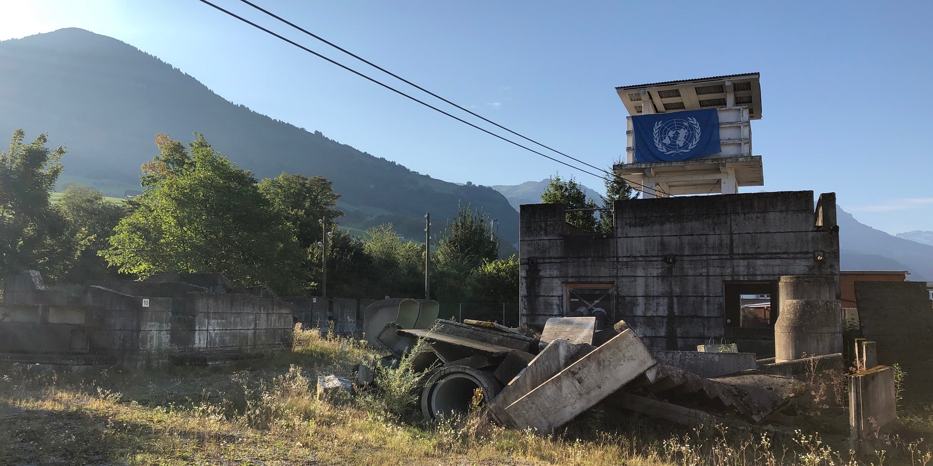 A white wooden tower flying a UN flag, set in the idyllic mountain landscape near Stans.