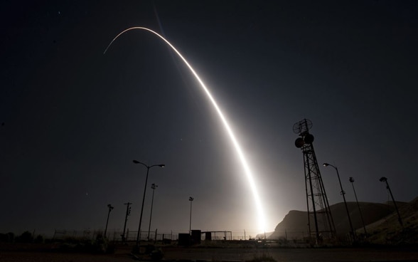 Un missile laisse derrière lui une traînée lumineuse dans le ciel nocturne. 