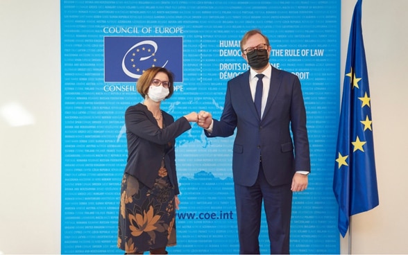 L’ambassadrice Anna Ifkovits Horner, cheffe de la division Eurasie, et Bjørn Berge, secrétaire général suppléant du Conseil de l’Europe, se serrent la main.
