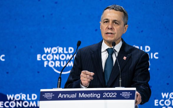 Le président de la Confédération Cassis se tient au pupitre et parle. En arrière-plan, un mur bleu sur lequel est écrit "World Economic Forum".