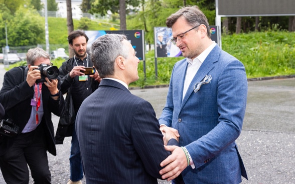 Le président de la Confédération Cassis et le ministre des Affaires étrangères Kuleba se saluent devant le bâtiment du centre de congrès de Davos.