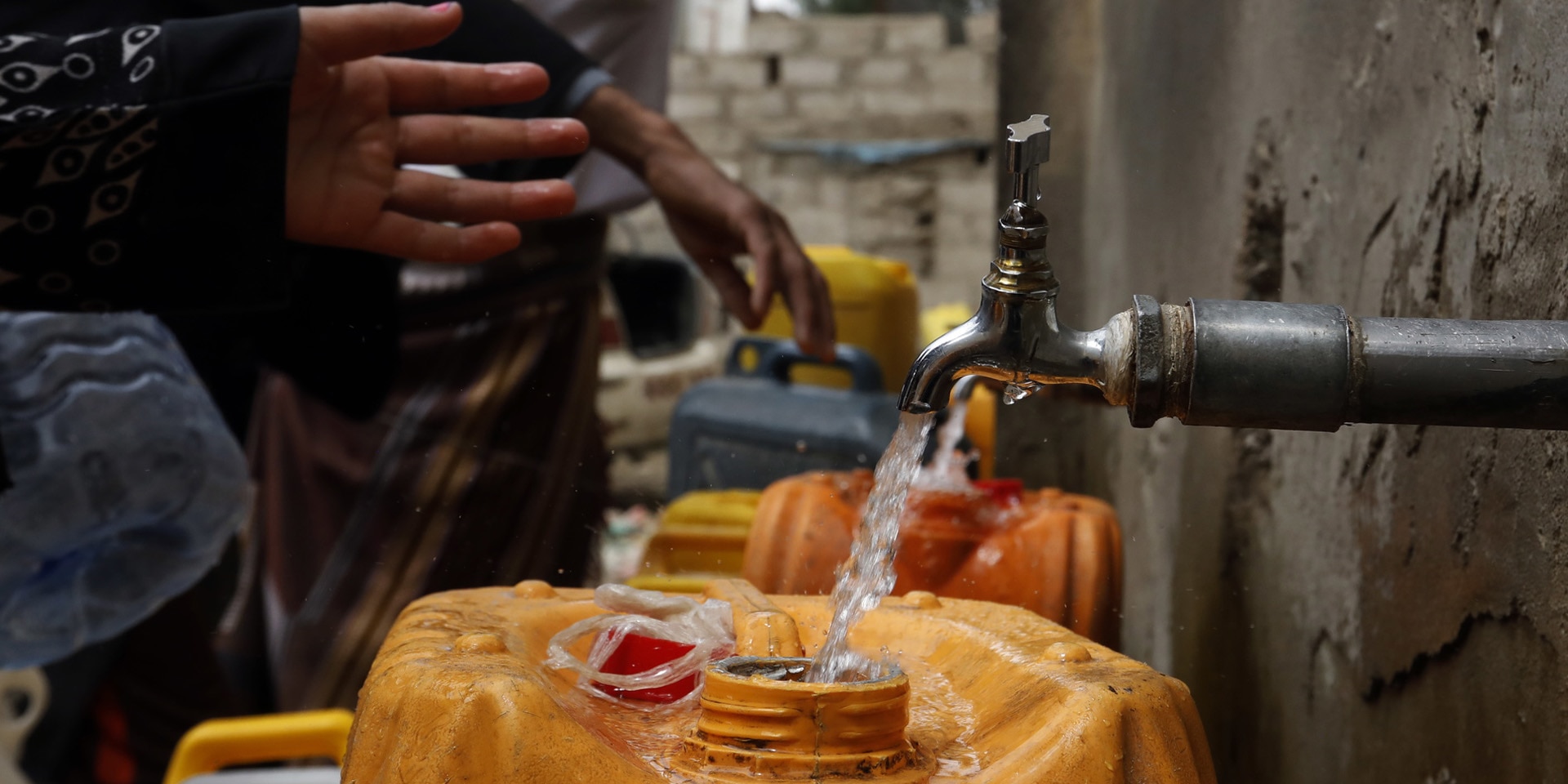 De l’eau potable coule d’un robinet dans un bidon jaune. 