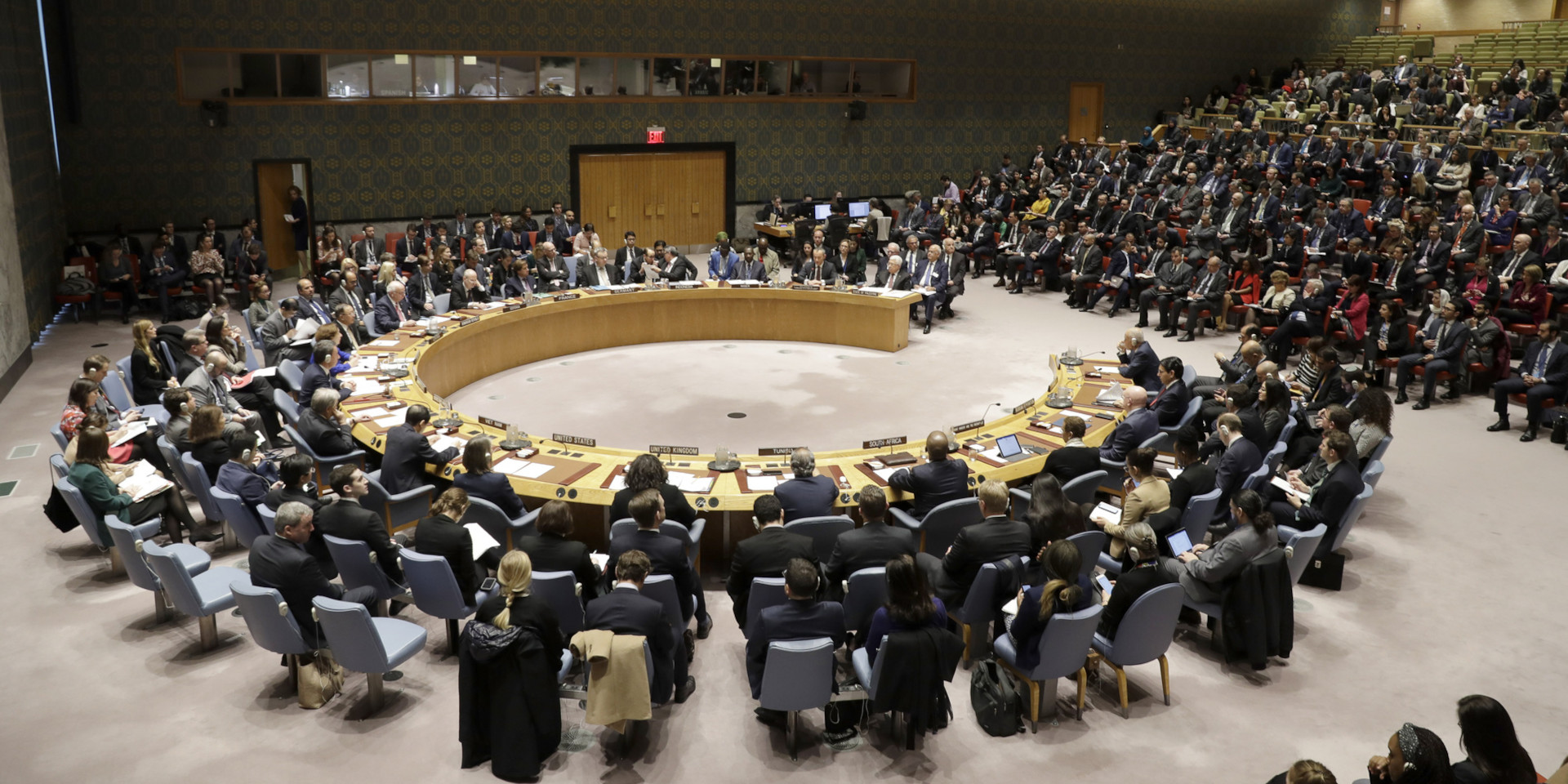 Photo du Conseil de sécurité de l'ONU: Des hommes et des femmes assis en demi-cercle.