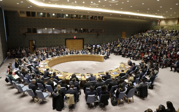 Bild vom UNO-Sicherheitsrat: Männer und Frauen sitzen im Halbkreis.