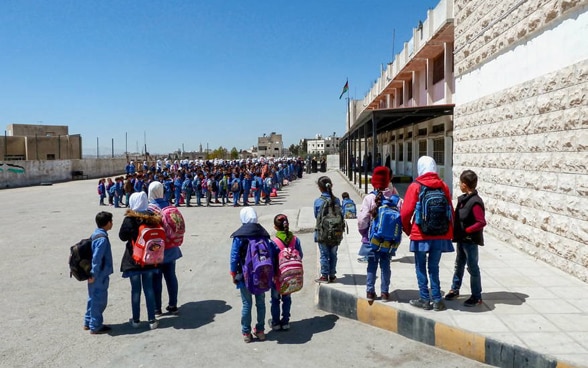 Des écoliers devant une école rénovée en Jordanie.