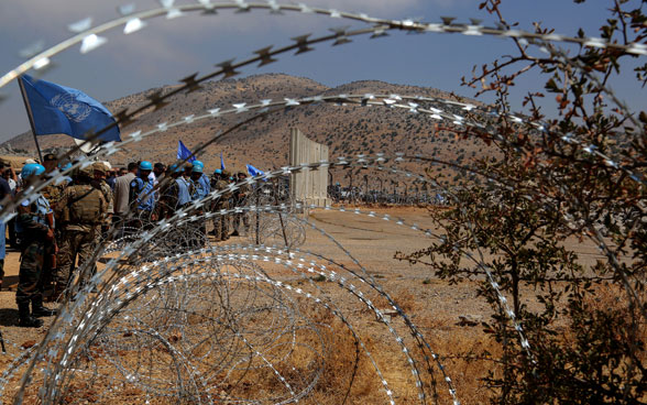 Des Casques bleus de l'ONU sont visibles depuis un fil de fer barbelé qui constitue la fameuse Ligne bleue entre le Liban et Israël.