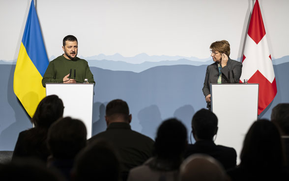 La présidente de la Confédération Viola Amherd est debout derrière un pupitre, à droite du président Volodymyr Selenskyi.