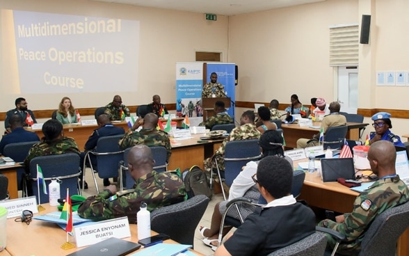 People at a training course sitting behind tables. 