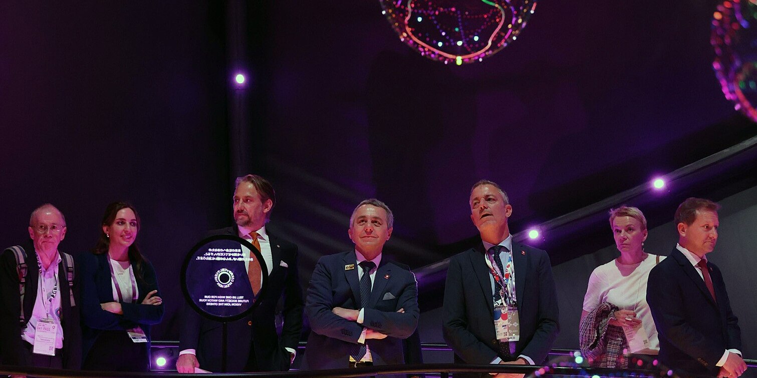  Foto del consigliere federale Cassis e della delegazione svizzera durante la visita del padiglione svizzero all'Esposizione mondiale di Osaka.