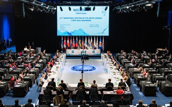 Members of the Arctic Council are sitting in a large hall.