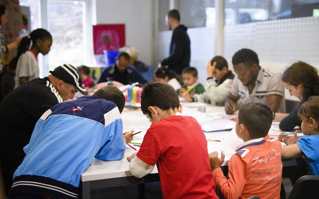 De nombreuses personnes sont assis à une table pour lire ou écrire