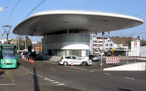 Un valico di frontiera molto trafficato a  Weil am Rhein, con automobili e tram.