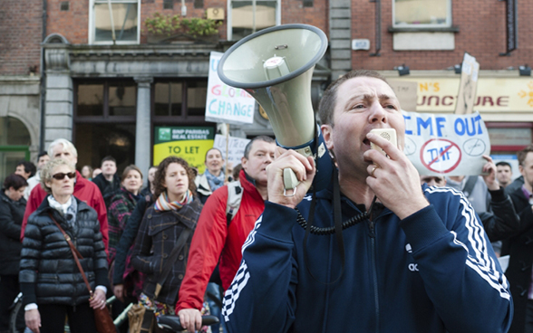 Ein Mann mit Megaphone führt eine Demonstration an in Dublin, 12 November 2011