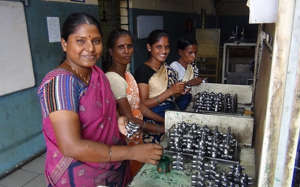 Arbeiterinnen bei der Endkontrolle von Autoteilen in einem SCORE-Unternehmen in Indien. 