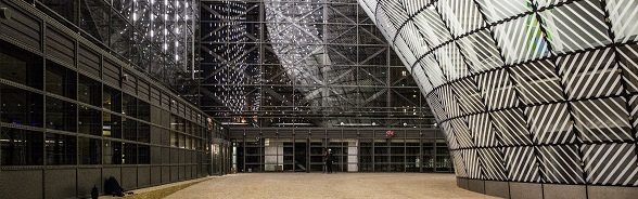 L’intérieur moderne du bâtiment Europa à Bruxelles : les murs et les façades sont composés de bois et de verre et sont illuminés. 