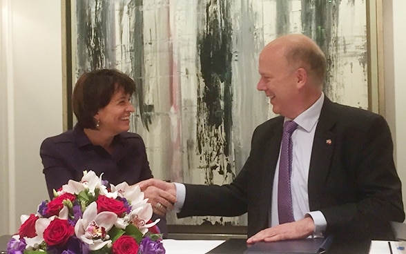La conseillère fédérale Doris Leuthard et le ministre des transports britannique Chris Grayling signent un accord sur le transport aérien