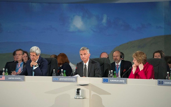  John Kerry, Didier Burkhalter et Catherine Ashton assis à la table de conférence.