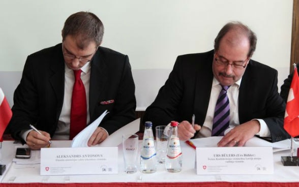 Le dernier accord de projet a été signé par Alexandre Antonovs, secrétaire d’État suppléant au Ministère des finances de Lettonie, et Urs Bühler, chargé d’affaires a.i.
