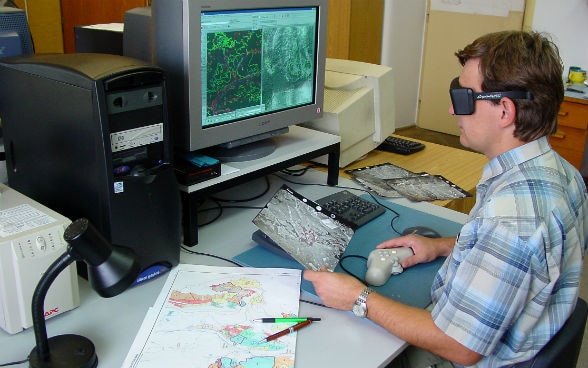 A man analysing a map on a computer screen