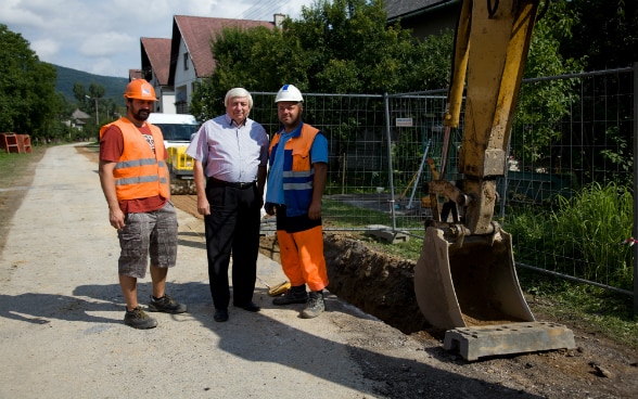 Une pelleteuse creuse une tranchée pour poser la canalisation.