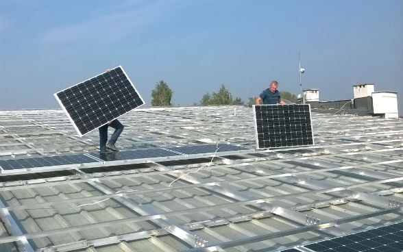 Due operai montano impianti fotovoltaici a Niepolomice, in Polonia.