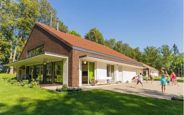 Children playing in a garden in front of a house