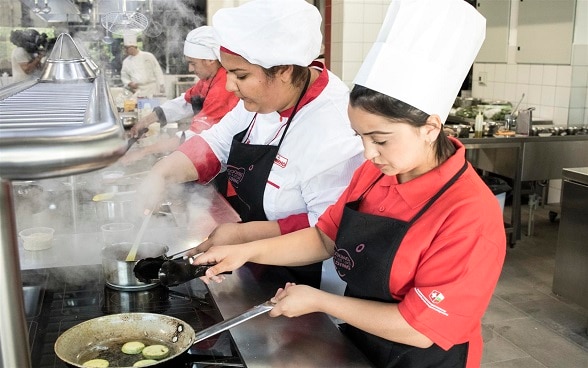 Donne al lavoro in una grande cucina.