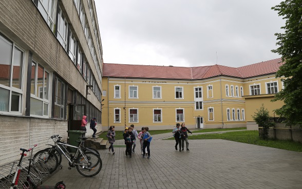 Schüler vor dem Schulgebäude. 