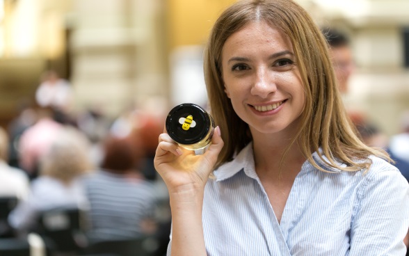 Jeune femme avec un pot de miel