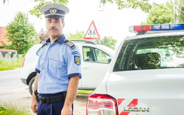 Un poliziotto sta vicino a un'auto. 