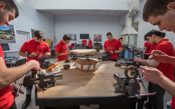 Berufssschüler sind in einer Werkstatt am Arbeiten