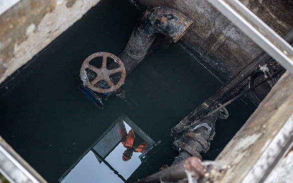A worker's reflection in the water at an old pumping station. 