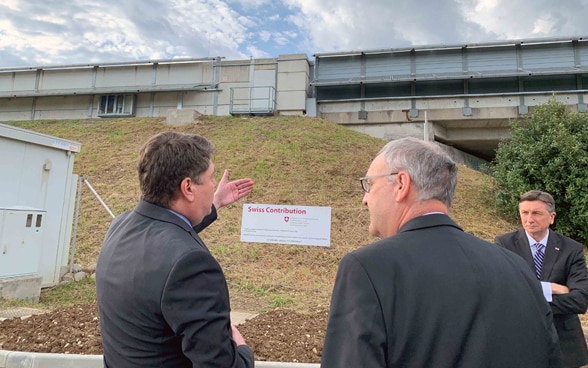 Präsidenten vor der mit Solarzellen bestückten Lärmschutzwand.