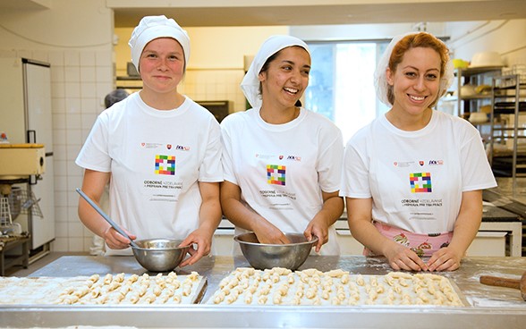 Three apprentices working in a bakery.